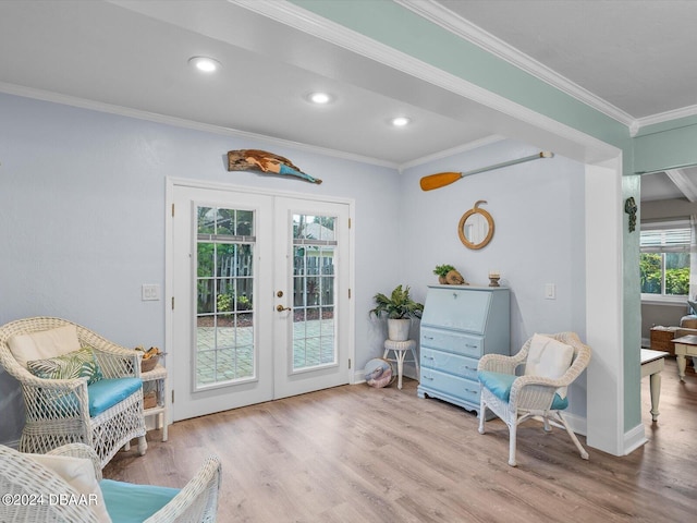 living area featuring crown molding, light wood-type flooring, and french doors