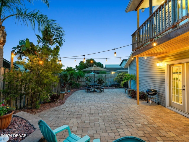 patio terrace at dusk featuring area for grilling