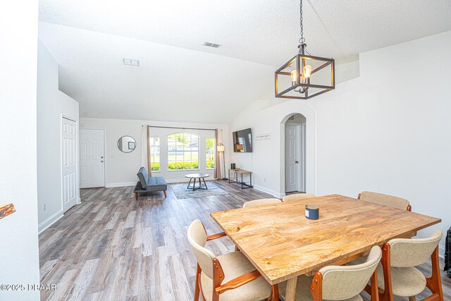 5 Zammer Ct, Palm Coast, FL 32164 - dining area featuring arched walkways, a chandelier, baseboards, wood finished floors, and visible vents