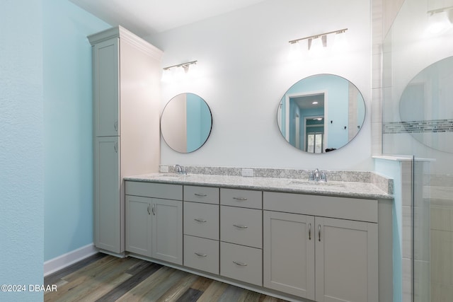 300 Blue Starfish Pl, Daytona Beach, FL 32124 - bathroom with double vanity, wood finished floors, a tile shower, and baseboards