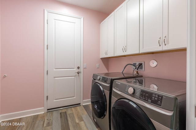 washroom featuring cabinets, washer and dryer, and light wood-type flooring