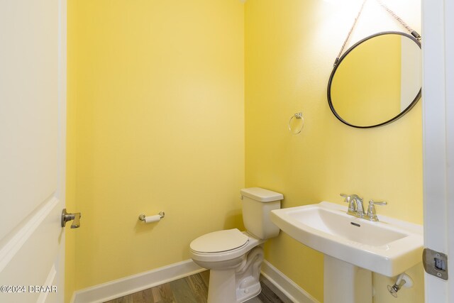 bathroom with wood-type flooring, sink, and toilet