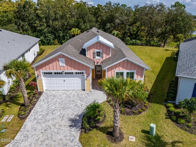 300 Blue Starfish Pl, Daytona Beach, FL 32124 - craftsman-style home with board and batten siding, an attached garage, driveway, and a front lawn
