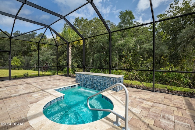 view of pool with pool water feature, a lanai, and a patio