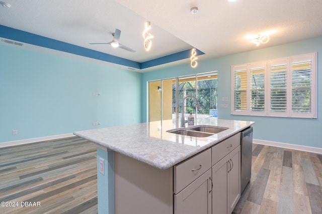 kitchen with hardwood / wood-style flooring, a center island with sink, sink, gray cabinets, and dishwasher