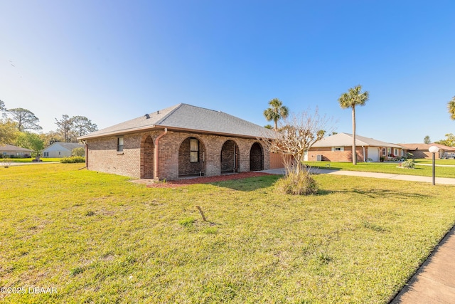 ranch-style home featuring a garage, a front lawn, brick siding, and driveway