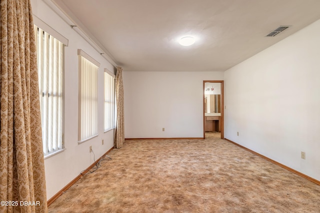 carpeted spare room featuring visible vents and baseboards