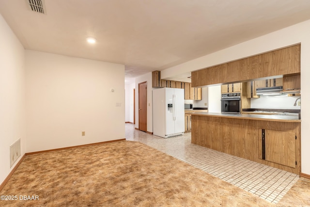 kitchen with visible vents, black oven, white refrigerator with ice dispenser, a peninsula, and exhaust hood