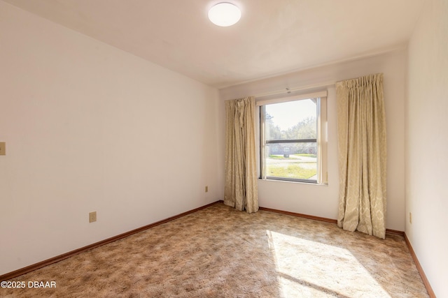 unfurnished room with baseboards and light carpet