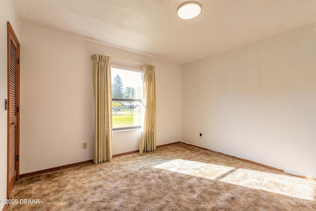 spare room featuring baseboards and carpet floors