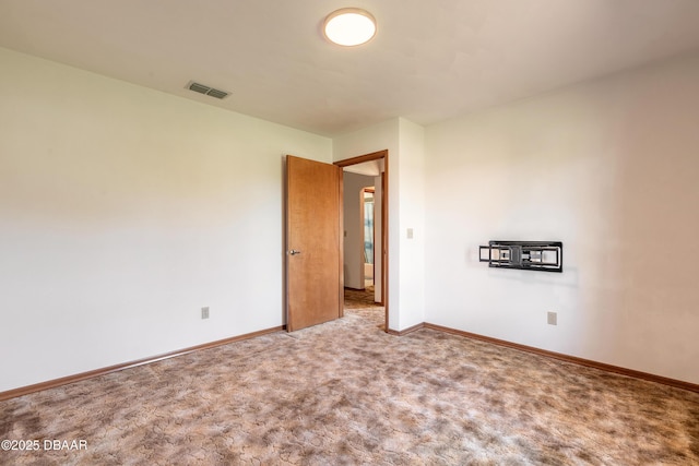 carpeted empty room with visible vents and baseboards