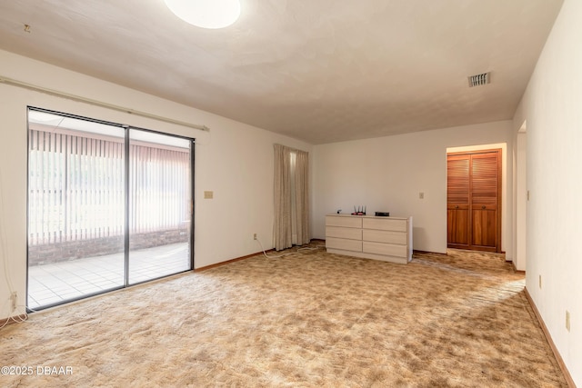 spare room featuring visible vents, carpet floors, and baseboards