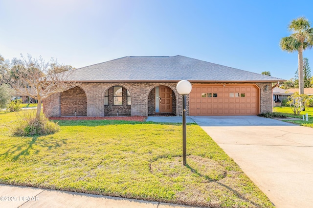 view of front facade featuring brick siding, a shingled roof, concrete driveway, a front yard, and a garage