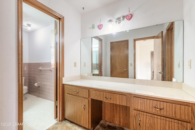 bathroom featuring tile walls, tile patterned floors, toilet, and vanity