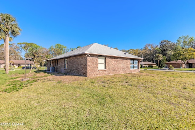 view of property exterior with brick siding and a lawn