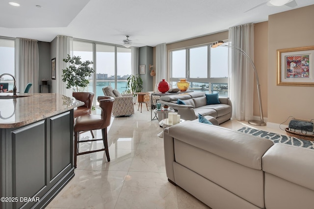 231 Riverside Dr Unit 901, Holly Hill, FL 32117 - living room featuring a ceiling fan, light marble finish floors, baseboards, and a water view