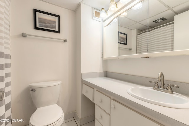 bathroom with a shower with curtain, a paneled ceiling, vanity, tile patterned flooring, and toilet