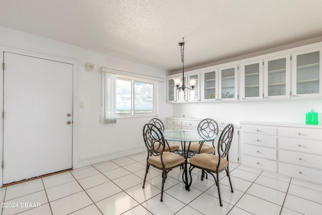 tiled dining area with a textured ceiling and a notable chandelier