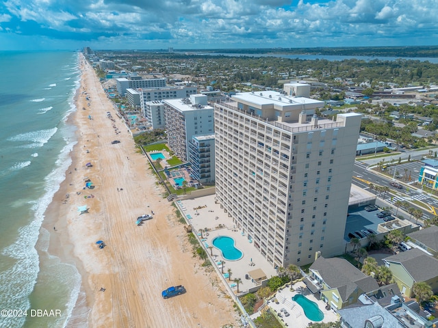 drone / aerial view with a water view and a beach view