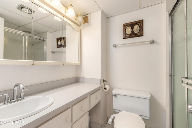 bathroom featuring vanity, toilet, and an enclosed shower