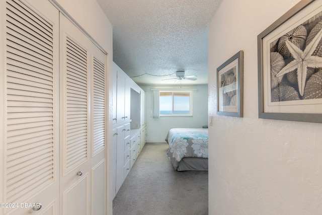 carpeted bedroom with a textured ceiling and a closet