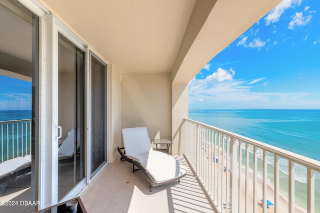 balcony featuring a beach view and a water view