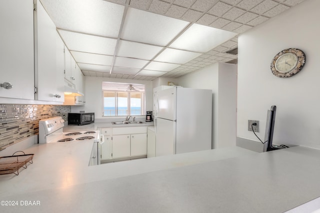 kitchen featuring a drop ceiling, white cabinets, sink, tasteful backsplash, and white appliances