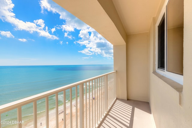 balcony featuring a water view and a beach view