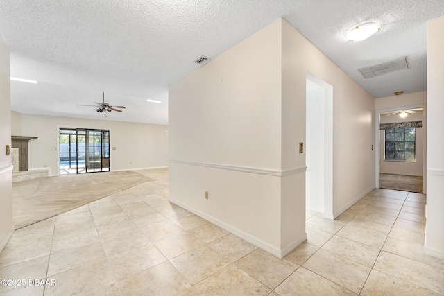 tiled empty room featuring ceiling fan and a textured ceiling