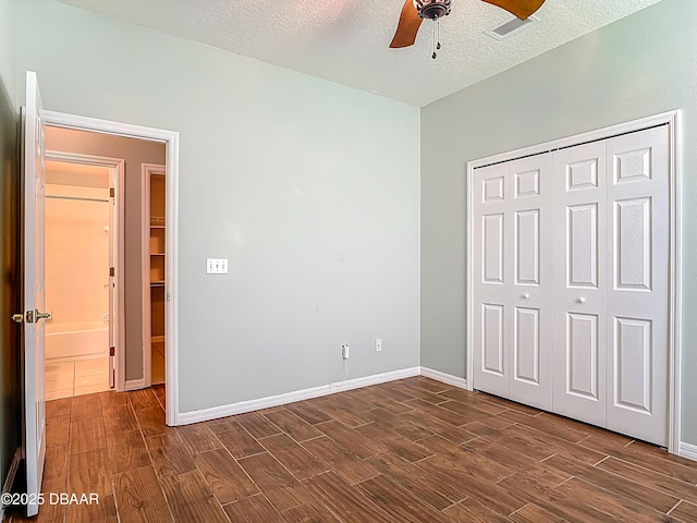 189 Perfect Dr, Daytona Beach, FL 32124 - unfurnished bedroom featuring dark wood-style floors, a textured ceiling, a closet, and ceiling fan