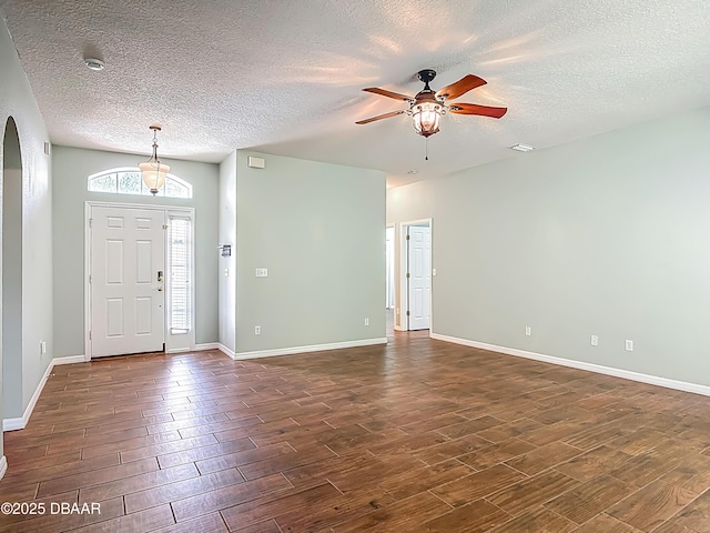 189 Perfect Dr, Daytona Beach, FL 32124 - foyer entrance featuring dark wood finished floors, a textured ceiling, ceiling fan, and arched walkways
