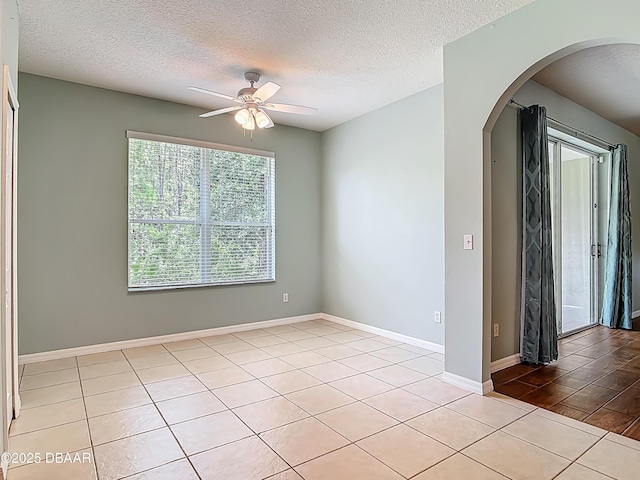 189 Perfect Dr, Daytona Beach, FL 32124 - unfurnished room featuring arched walkways, ceiling fan, a textured ceiling, and light tile patterned floors