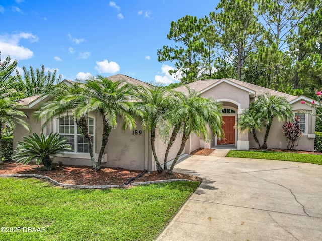 189 Perfect Dr, Daytona Beach, FL 32124 - view of front facade with driveway, stucco siding, a garage, and a front yard