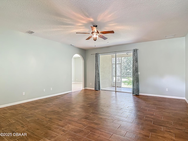 189 Perfect Dr, Daytona Beach, FL 32124 - spare room featuring arched walkways, ceiling fan, dark wood finished floors, and a textured ceiling