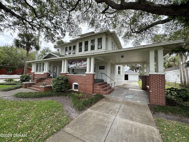 view of front of home with covered porch, an outdoor structure, and a garage