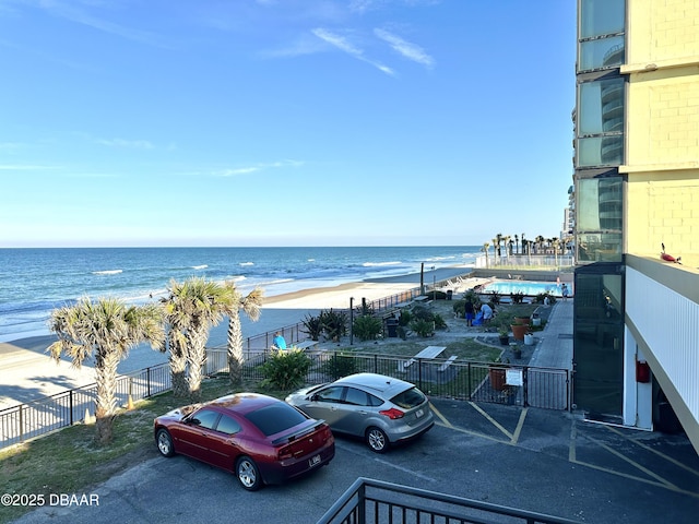 view of water feature with a beach view and fence