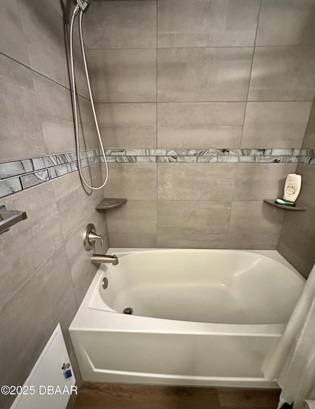 bathroom with wood finished floors, shower / tub combo with curtain, and tile walls