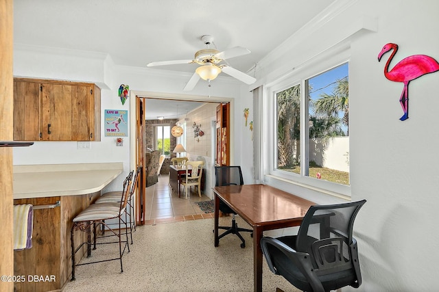 dining space with light speckled floor, ornamental molding, and a ceiling fan