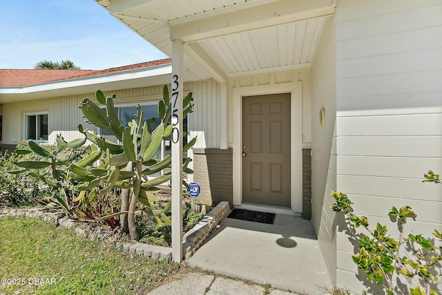 doorway to property featuring a shingled roof