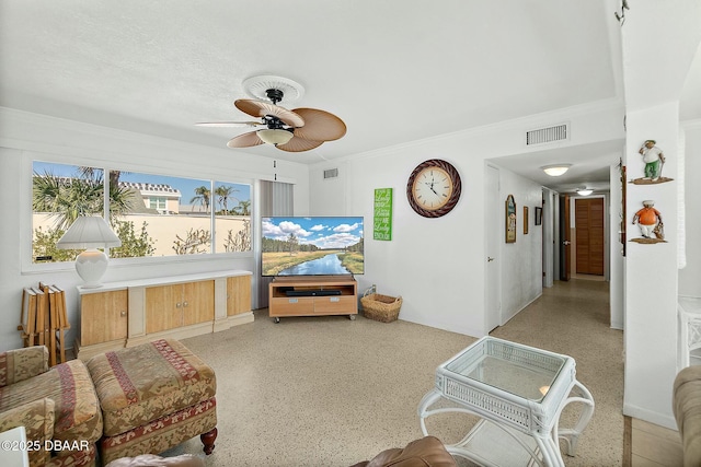 living room featuring visible vents, light speckled floor, crown molding, and ceiling fan