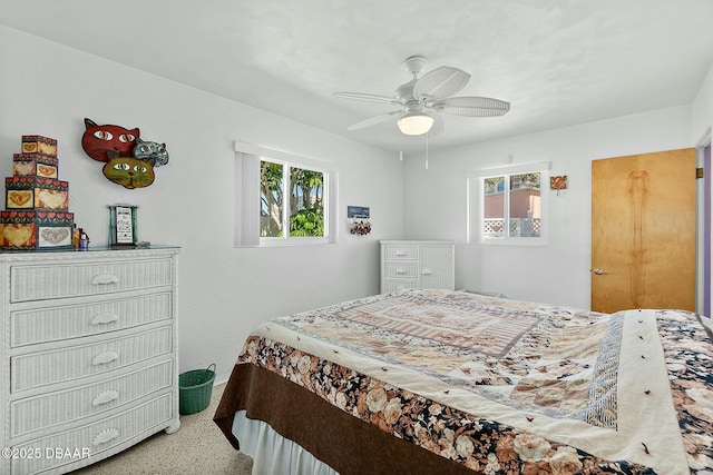 bedroom with multiple windows, a ceiling fan, and speckled floor