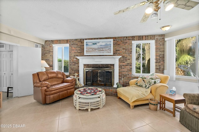 living area with a brick fireplace, light tile patterned floors, brick wall, and a textured ceiling