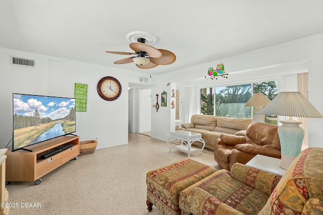 living area featuring visible vents, a ceiling fan, speckled floor, and crown molding