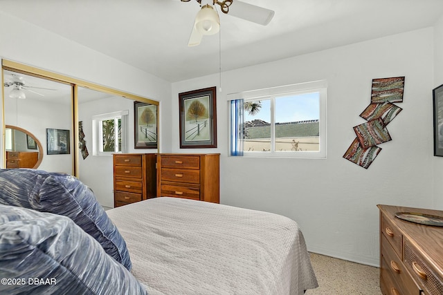 bedroom with a ceiling fan, light speckled floor, and a closet