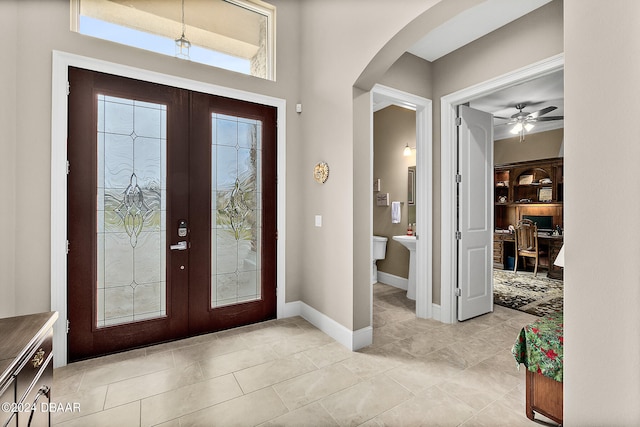 tiled foyer featuring ceiling fan and french doors