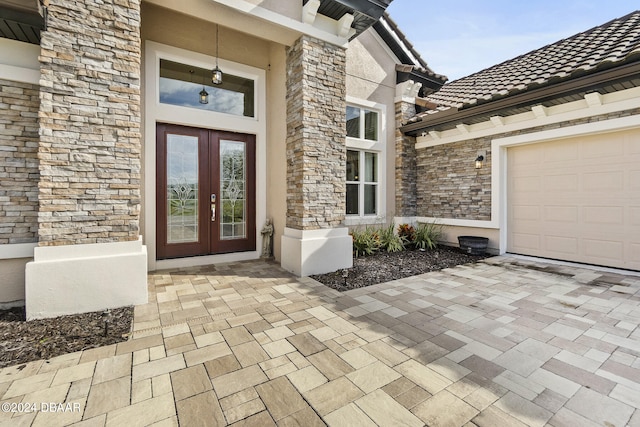 view of exterior entry featuring french doors and a garage