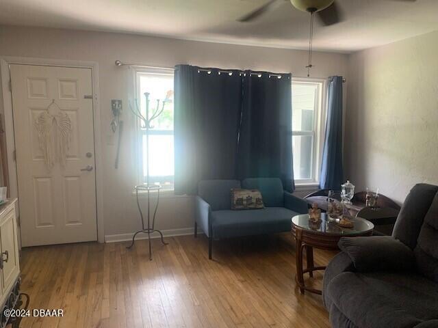 sitting room featuring light wood-type flooring, a healthy amount of sunlight, ceiling fan, and baseboards