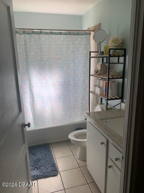 full bathroom featuring shower / tub combo with curtain, vanity, toilet, and tile patterned floors