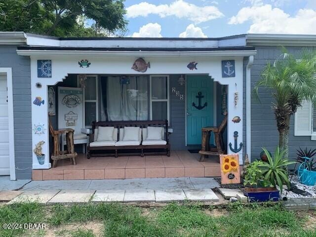 view of exterior entry with covered porch