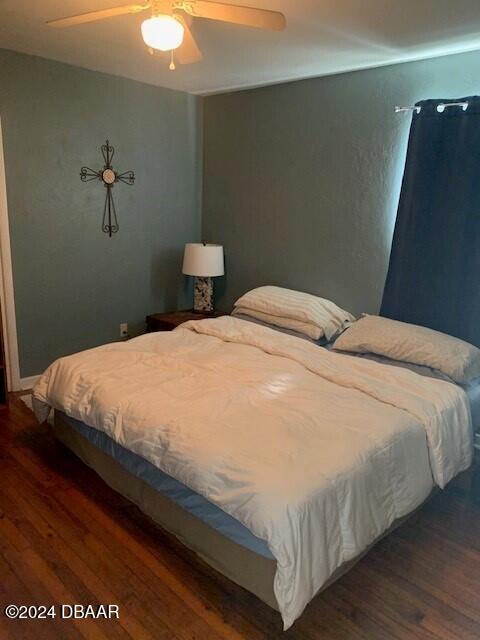 bedroom with dark wood-style flooring and ceiling fan